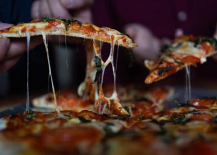 Freshly baked pizza being served with melted cheese